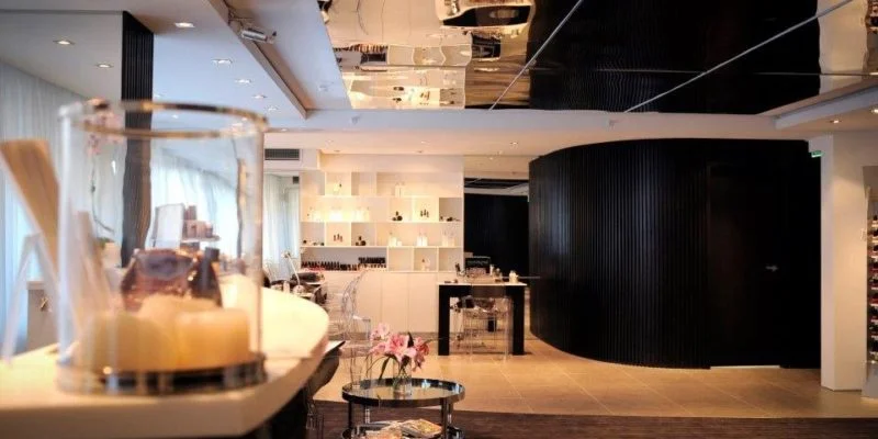 You Day Spa retail gallery — white shelving and warm-lit counter with candle